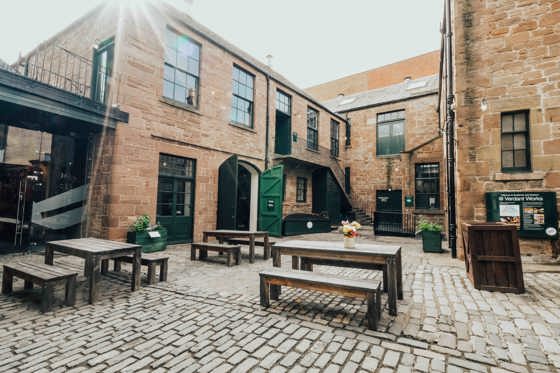 Verdant Works courtyard with picnic benches and green doors